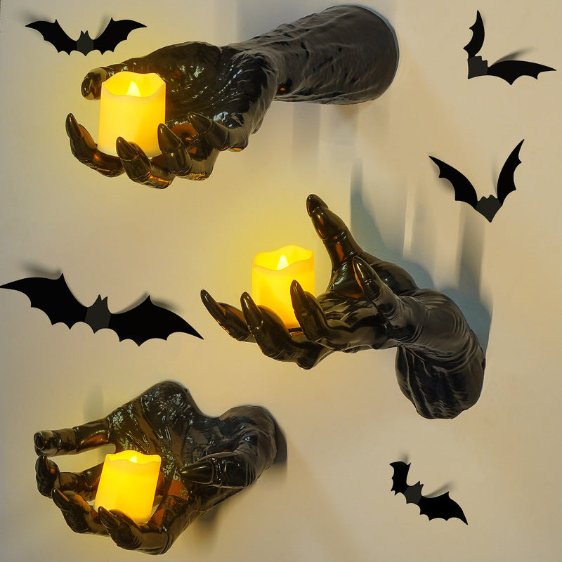 Gothic Halloween indoor decor with black hands holding lit candles and bat wall stickers for spooky gothic walls